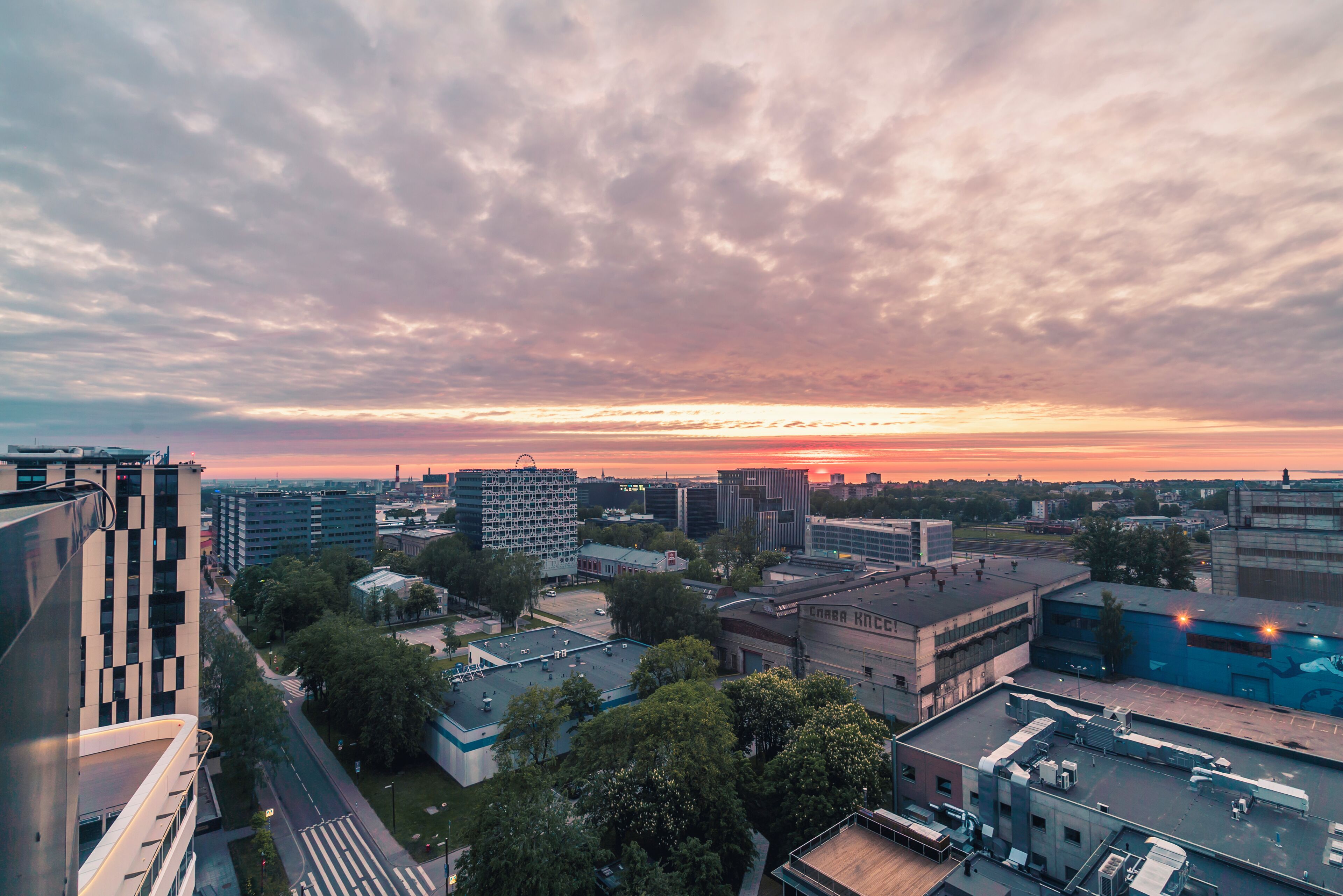 Eine Stadtlandschaft mit modernen Gebäuden, blauem Himmel und Sonnenuntergang.