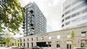 A modern building with a sign reading "LURICH" on the facade, featuring a mix of brick and glass construction. - LURICH Residences (Tallinn)