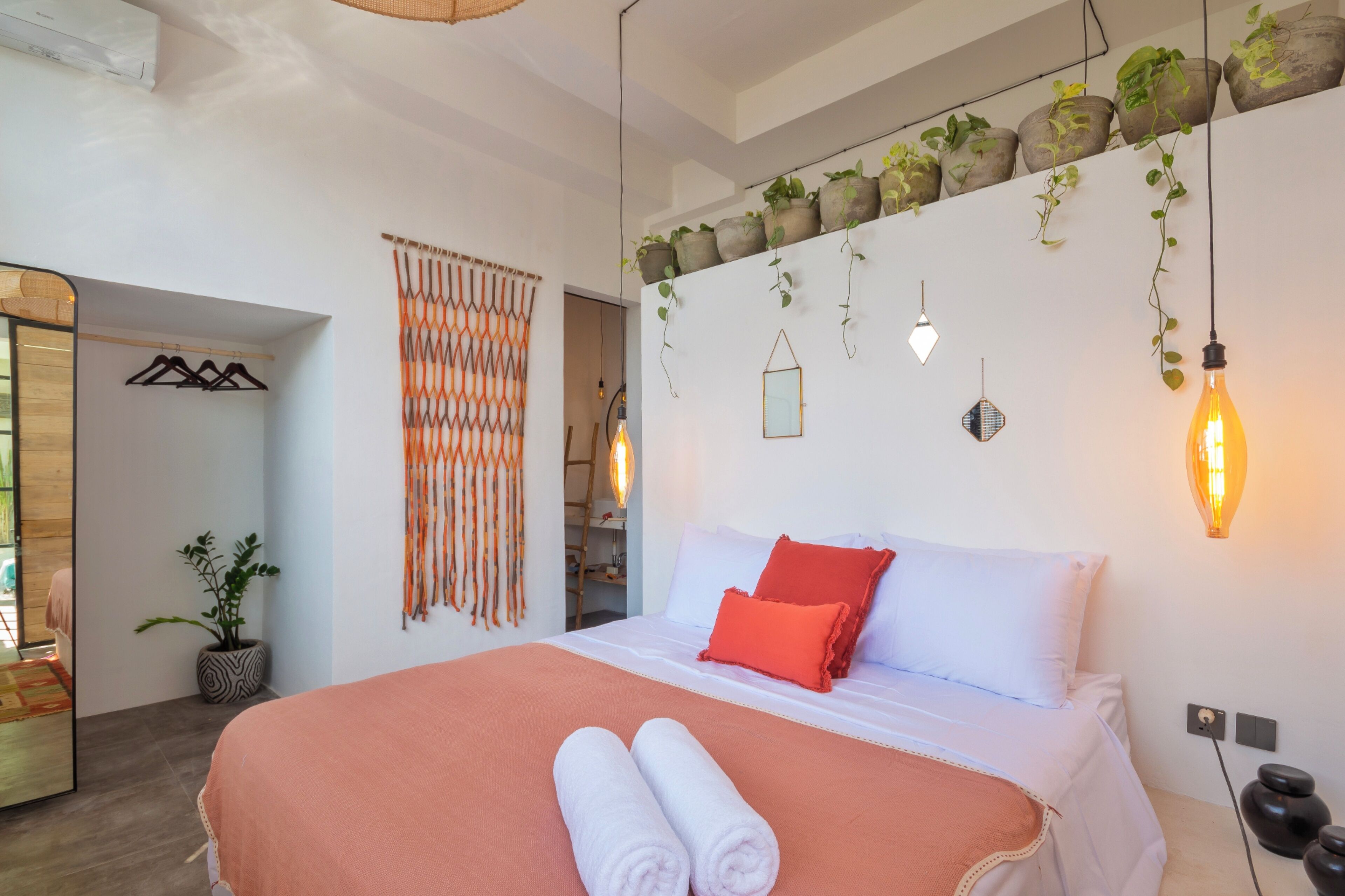 Une chambre moderne avec un grand lit, un mur végétal et un miroir.