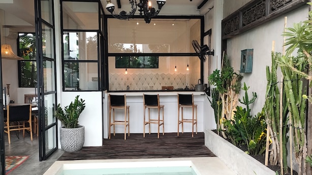 A modern outdoor pool area with a bar and seating. - MariNara Lofts (Canggu)