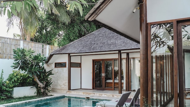 A modern house with a swimming pool, large glass doors, and a well-maintained garden. - Ningaloo Villa (Gili Trawangan)