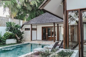A modern house with a swimming pool, large glass doors, and a well-maintained garden. - Ningaloo Villa (Gili Trawangan)