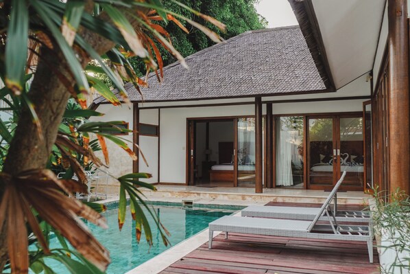 A modern house with a swimming pool, large glass doors, and a wooden deck. - Ningaloo Villa (Gili Trawangan)