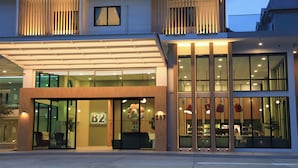 A modern hotel with a glass facade, numbered rooms, and a covered entrance. - B2 Ubon Airport Premier Hotel (Ubon Ratchathani)