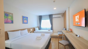 A hotel room with two beds, a desk, a chair, a TV, and artwork on the walls. - B2 Ubon Airport Premier Hotel (Ubon Ratchathani)