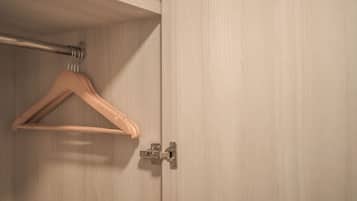 Un perchero de madera en una barra metálica en una habitación con paneles de madera clara.