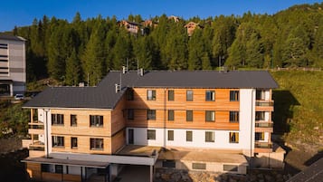 Ein mehrstöckiges Gebäude mit Flachdach, Holzfassade und Balkonen.