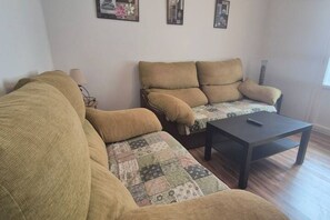 Ein Wohnzimmer mit einer Couch, einem Couchtisch und einer Lampe.