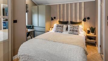Une chambre moderne avec un grand lit, des lampes de chevet, une table de chevet et un miroir.