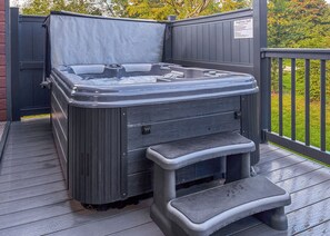 A hot tub on a wooden deck with a metal railing and a sign indicating it's for use at Snainston Golf. - 1 bedroom accommodation in Snainton Luxury Lodges (Snainton Luxury Lodges)