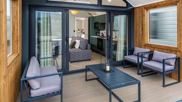 Un intérieur moderne avec une porte vitrée donnant sur un espace de vie, un canapé et une table avec des chaises.