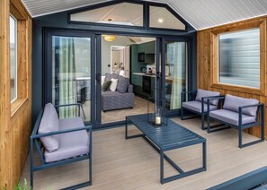A modern interior with a glass door leading to a living area, a sofa, and a table with chairs.