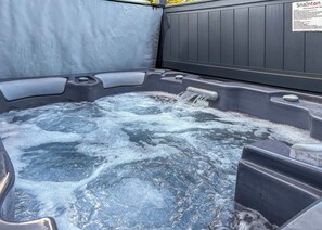 A hot tub with a wooden wall and a sign with safety instructions. - 1 bedroom accommodation in Snainton Luxury Lodges (Snainton Luxury Lodges)