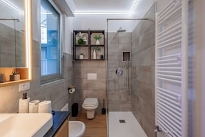 Un baño moderno con ducha, inodoro y lavamanos.