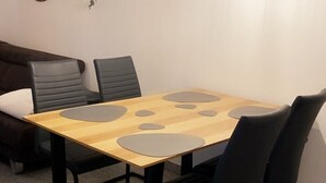 A modern dining area with a wooden table and four black chairs.