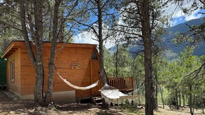 A wooden cabin with a hammock, surrounded by trees and mountains. - Glamping Moret Tiny House M1 Cabaña Para 2 Personas-pet Friendly (Arteaga)