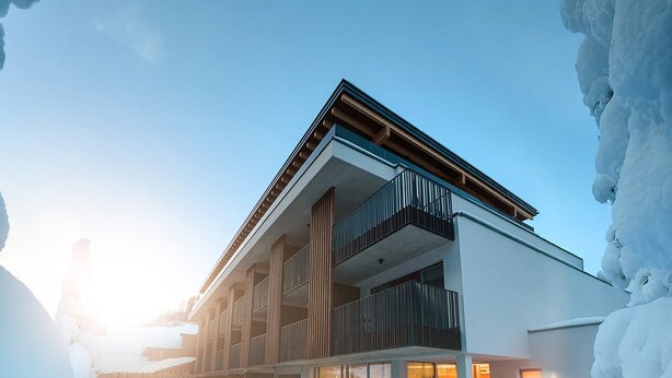 A modern building with a glass pool, surrounded by snow. - LH Linzerhaus Suites Saalbach – inklusive Jokercard (Saalbach-Hinterglemm)