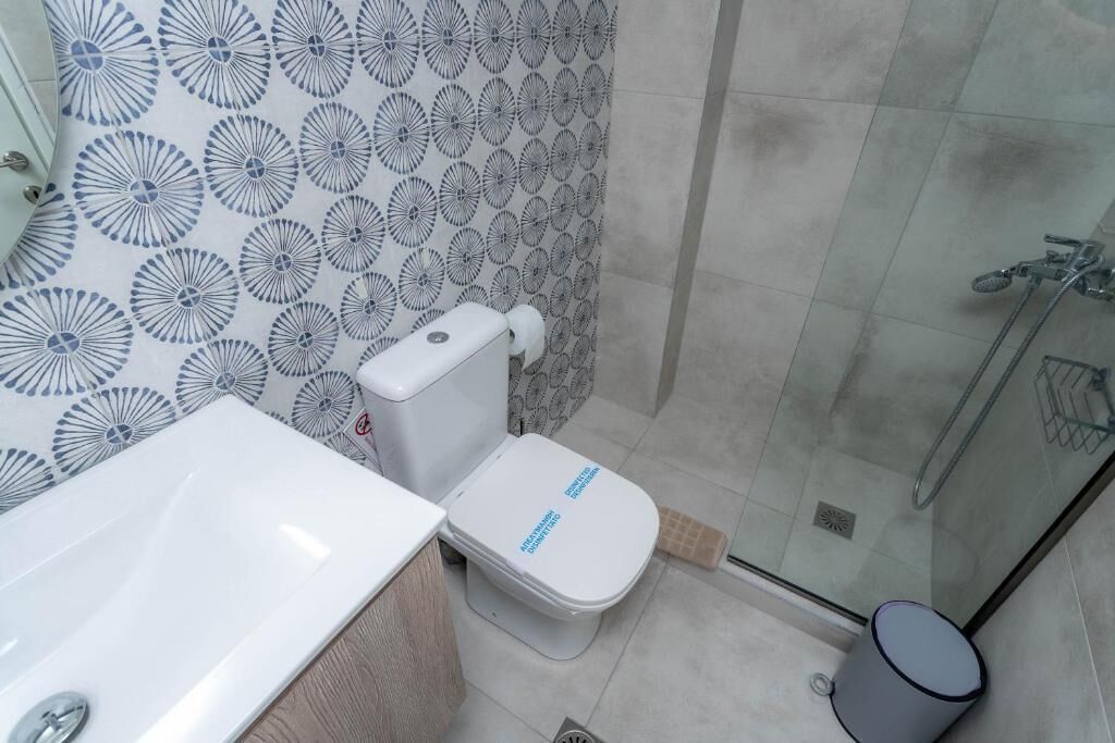 A bathroom with a toilet, sink, and shower.