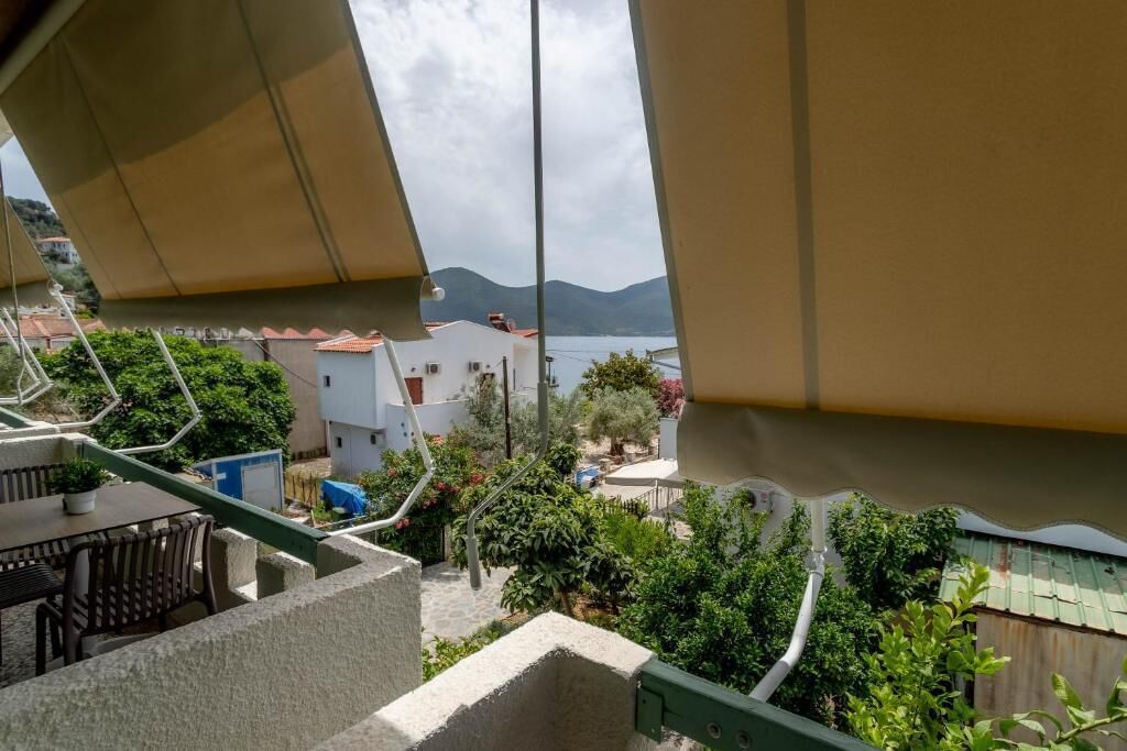 A balcony with a view of a coastal town, including houses and a body of water.