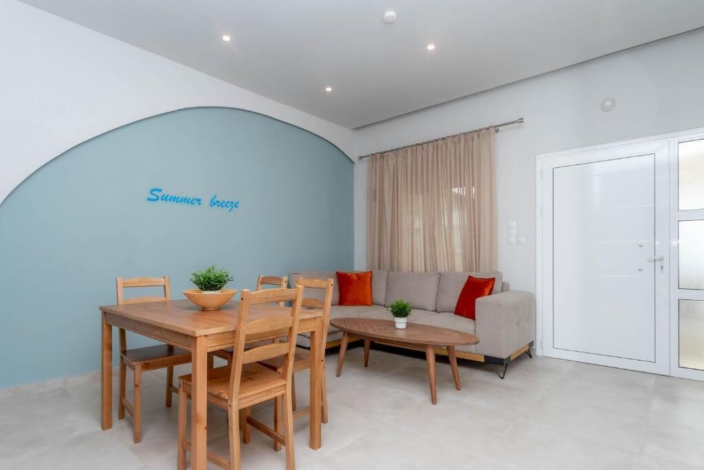 A modern living room with a dining table, chairs, a sofa, and a small coffee table.