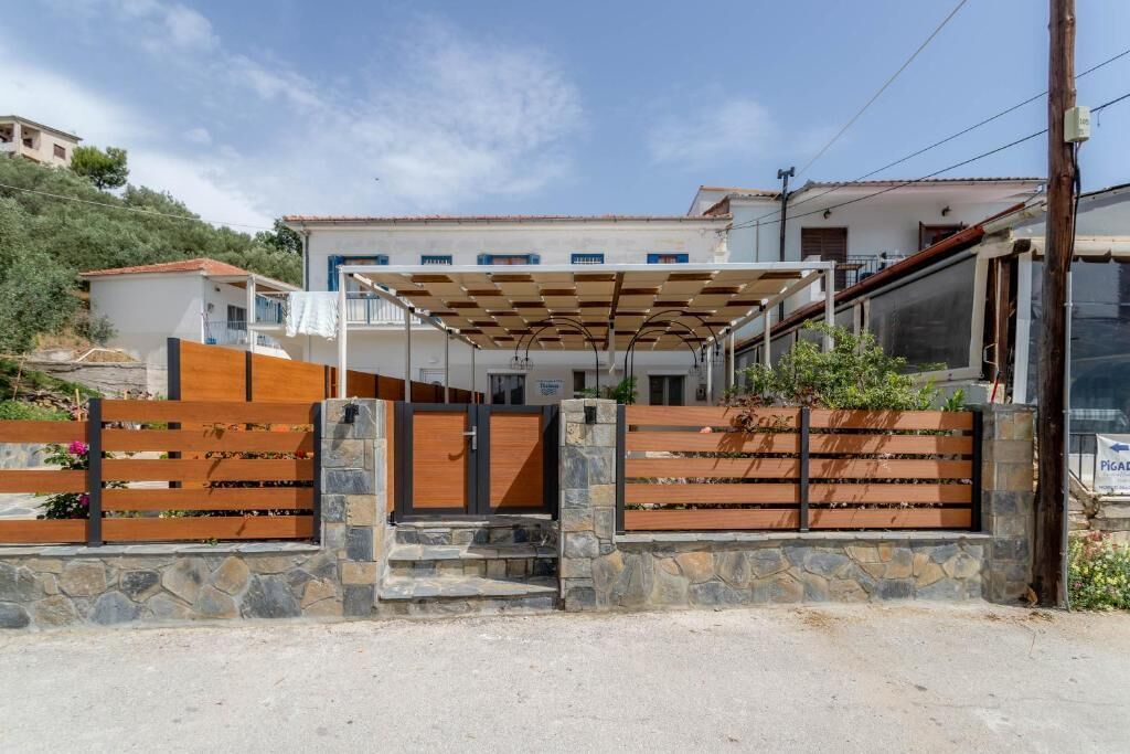 A residential property with a gated entrance, a covered patio, and a stone wall.