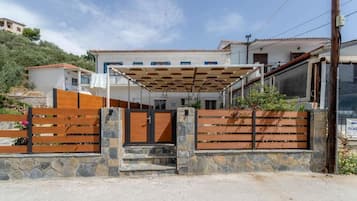 A residential property with a gated entrance, a covered patio, and a stone wall.