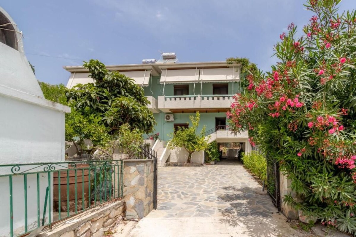 A two-story building with a stone pathway leading to the entrance.