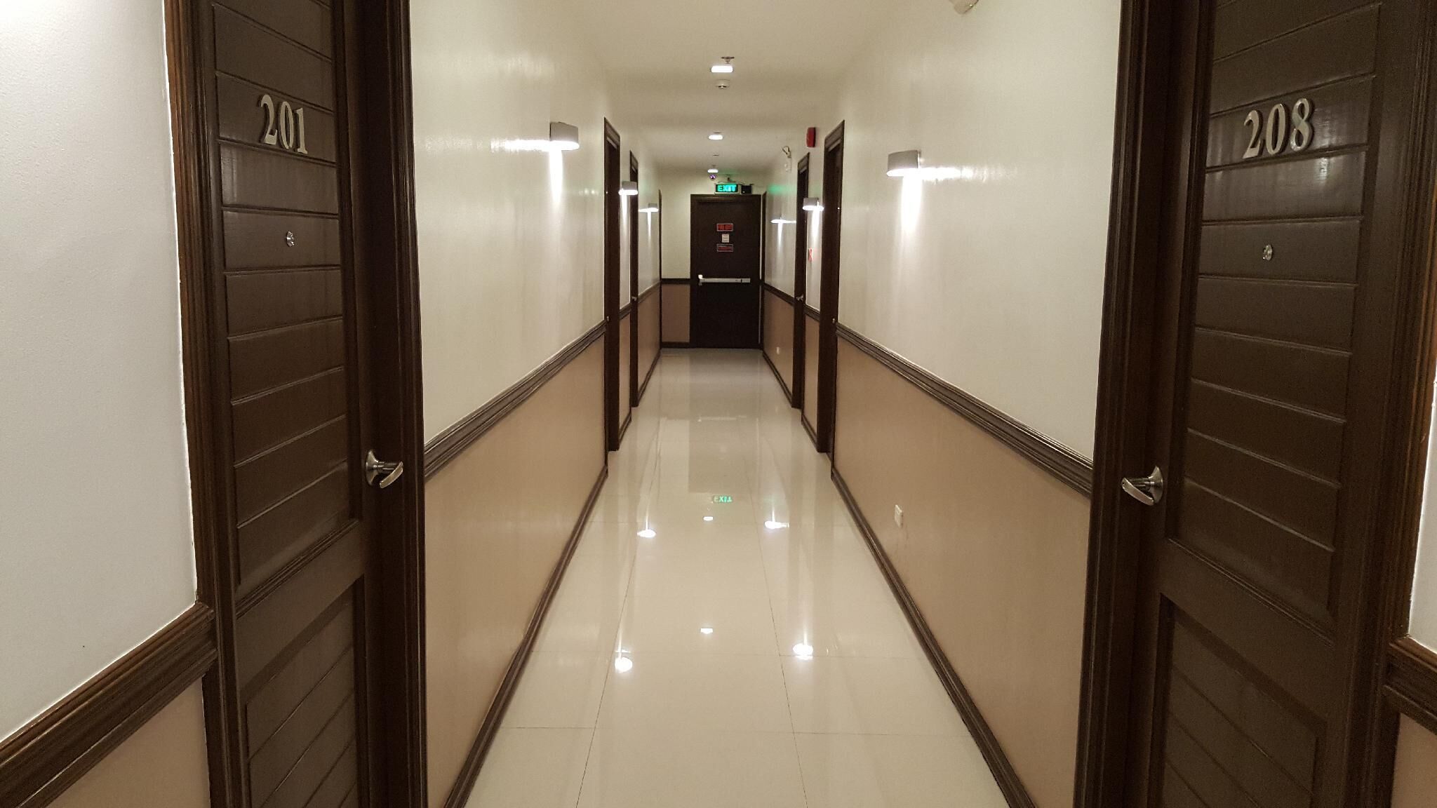 A hotel hallway with doors numbered 201 and 208, leading to an exit.