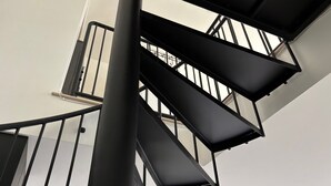 A spiral staircase with black railings and a white wall in the background. - Cozy 1-bedroom/studio with AC, WiFi 5 min from Palo Alto in Menlo Park (Menlo Park)