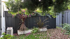 A garden with various plants and a wooden fence. - Cozy 1-bedroom/studio with AC, WiFi 5 min from Palo Alto in Menlo Park (Menlo Park)