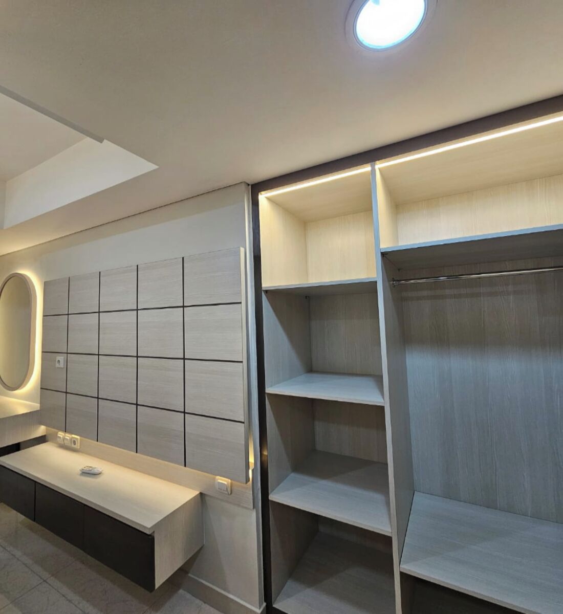 Une salle de bain moderne avec un meuble-lavabo, un miroir et des étagères intégrées.