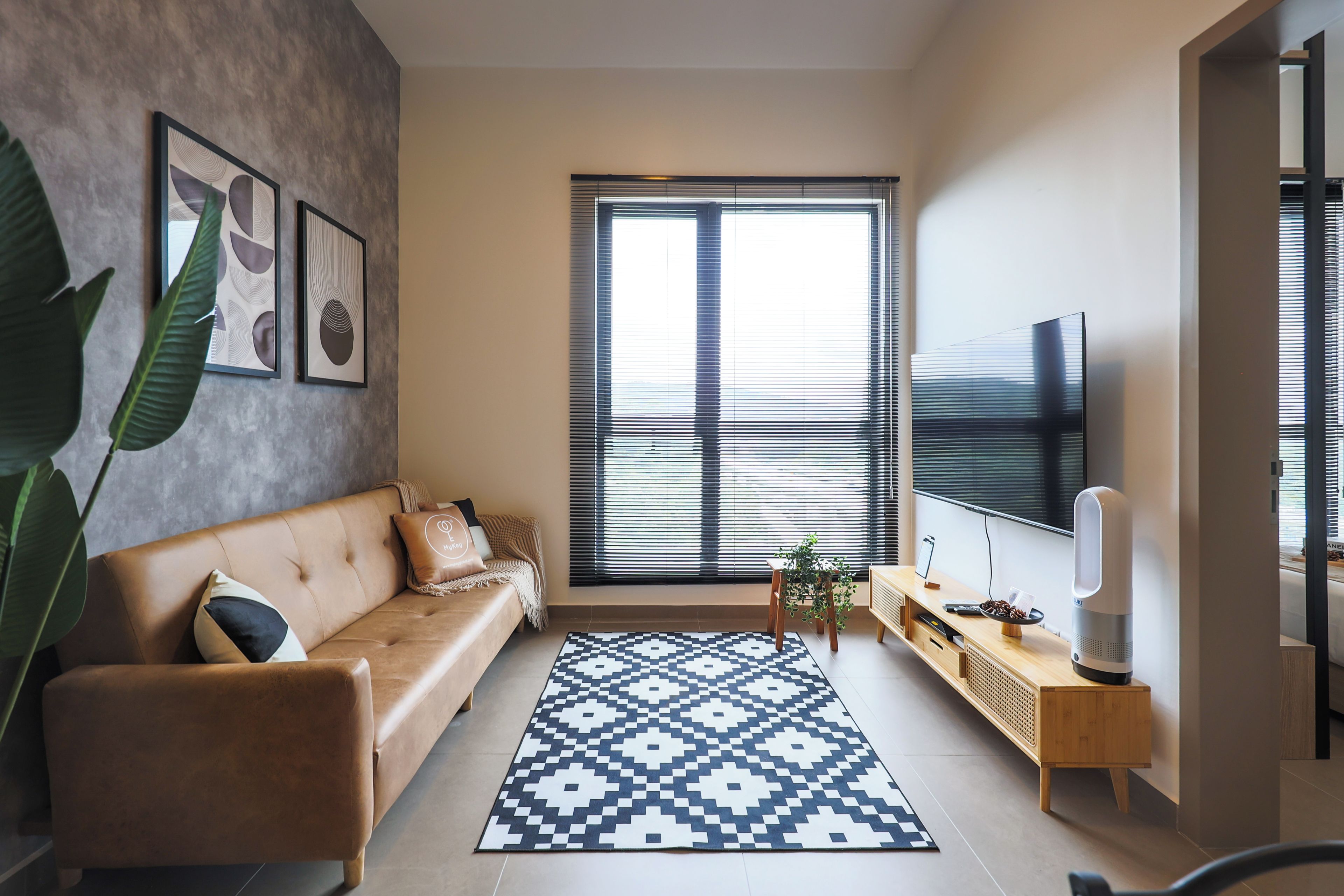 A modern living room with a sofa, a coffee table, a TV, and a large window with blinds.