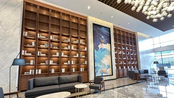 Eine moderne Lobby mit einer gro ßen Bücherwand, einem Sofa und einem Couchtisch.