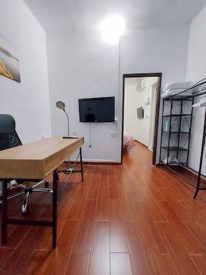 Cozy retreat with a flat-screen TV, desk, and metal shelf unit.