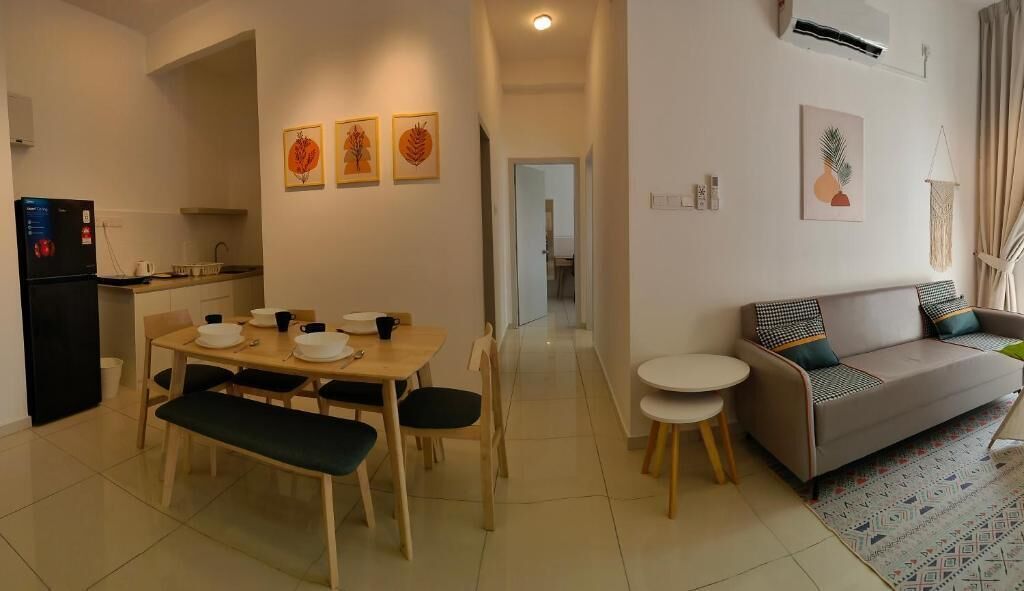 Una sala de estar moderna con un sofá, una mesa de comedor con sillas y una zona de cocina con refrigerador.