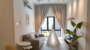 A modern living room with a sofa, a small round table, a dining table, a tent-like structure, and a potted plant. - The Horizon by MyKey (Ipoh)