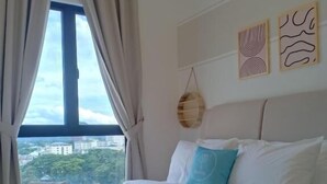 A hotel room with a large bed, a view of the city, and two wall art pieces. - The Horizon by MyKey (Ipoh)