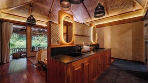 Une cuisine moderne avec des meubles en bois, un plan de travail noir et une vue sur le jardin grâce à de grandes fenêtres.
