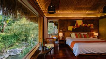 A room with a bed, bedside table, and a view of a natural landscape.