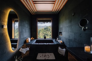 A modern bathroom with a large window, a bathtub, and a sink.