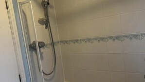 Ein Badezimmer mit Dusche, Badewanne und Toilette.