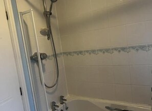 Een badkamer met een douche, bad en toilet.