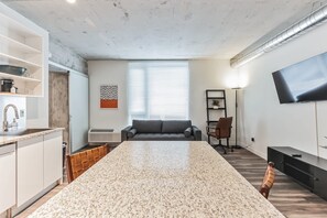 Une cuisine moderne dotée de plans de travail en granit, d’un four encastré et d’un coin repas avec une grande table en granit.