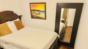 A neatly made bed with a white quilt, two brown pillows, and a painting of a sunset over a river on the wall. - Affordable Charming and Spacious  1 bedroom in delightful Queens New York (Queens)