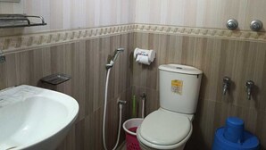 A small bathroom with a toilet, sink, and shower. - Hotel City View (Dhaka)