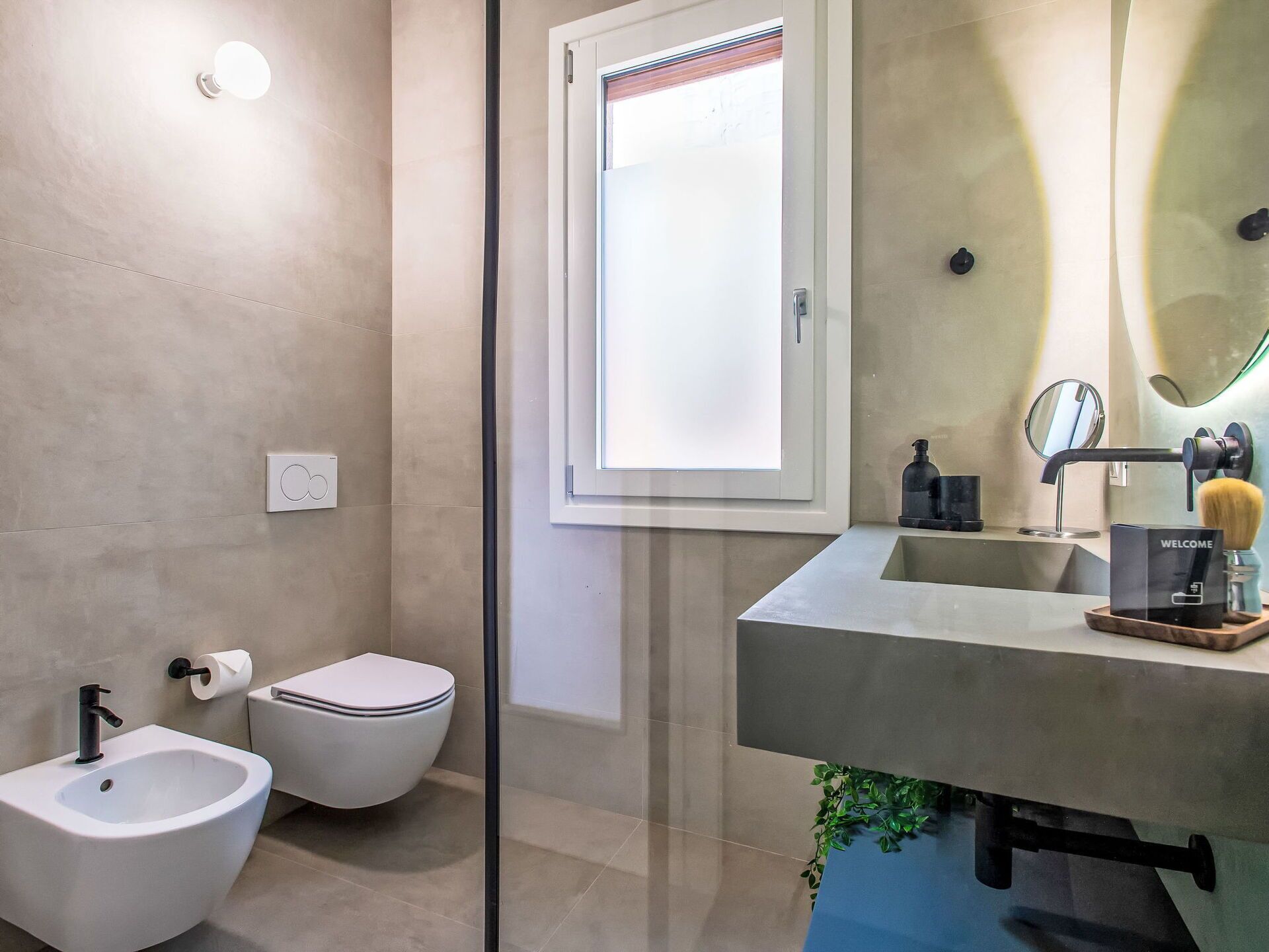 Een moderne badkamer met een hygiëneschuiver, toilet en wastafel.