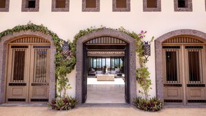 Un edificio con tres aberturas en arco, cada una con una puerta de madera y un ventanal.