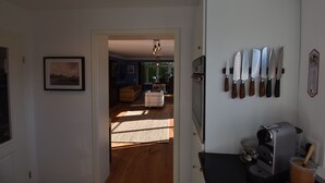 A kitchen with a coffee machine, a knife rack, and a framed picture on the wall. - Sunny 4-room garden apartment with pool near the lake for up to 6 people (Eriskirch)