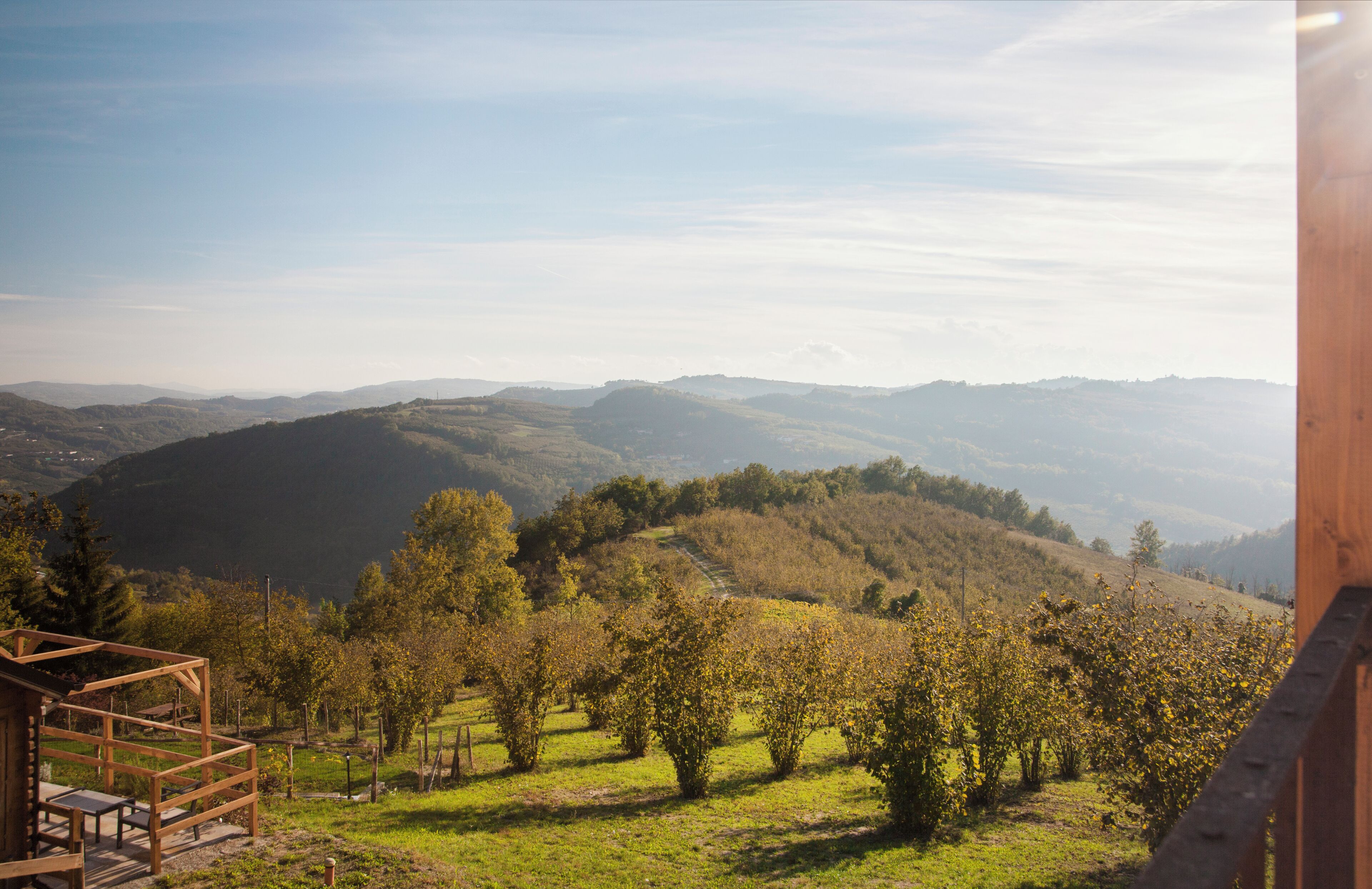 Una cabaña de madera con vistas a colinas onduladas y montañas distantes.