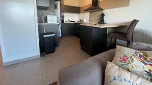 A compact kitchen with a microwave, coffee maker, and a small island.
